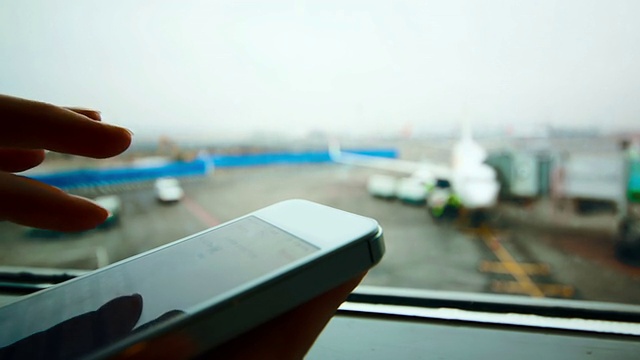 一名女子在机场使用智能手机视频素材