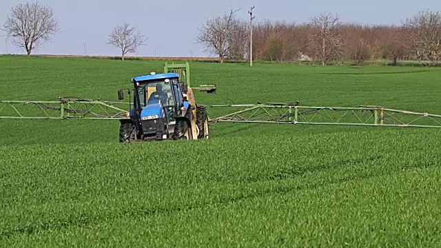 拖拉机在田间喷洒，农村景观在农村视频素材