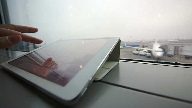 在机场的窗台上使用平板电脑视频素材