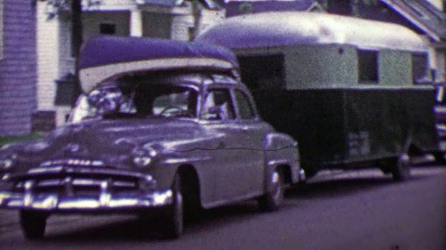 1953年:家庭卡车装载独木舟和野营拖车度假。视频下载