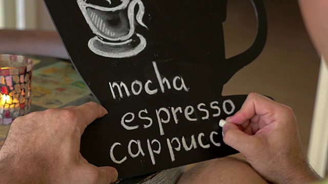 男人在黑板上写咖啡的种类视频下载