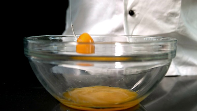 厨师将生鸡蛋放入玻璃碗中视频素材