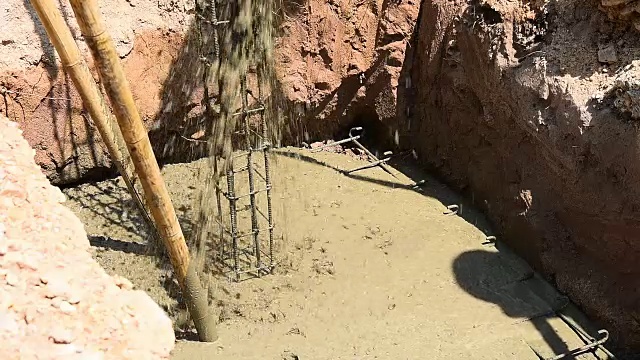 建筑工人用水泥搅拌机浇筑混凝土混合物。视频素材
