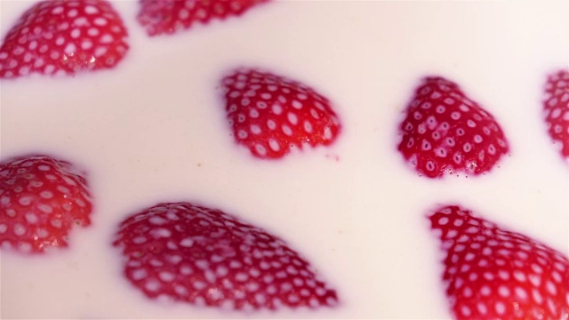 草莓落入牛奶的慢动作视频视频素材