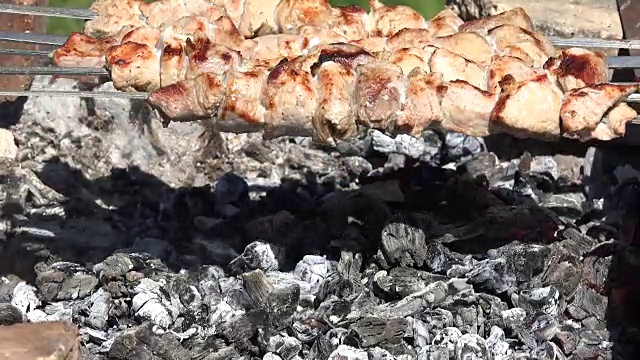 特写的新鲜的肉烤在钢制烤肉串在烟在复古花园壁炉。视频下载