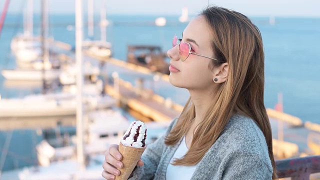 年轻女子在吃冰淇淋。视频下载