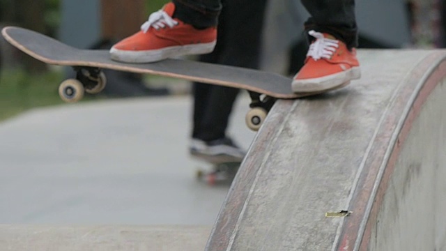 一个滑板者在一个滑板公园做把戏的近视图视频下载