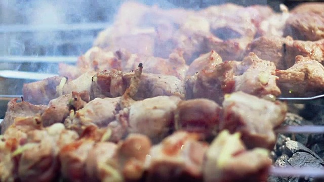 在木炭上烤肉。用烤肉串烤羊肉串。特写镜头视频素材