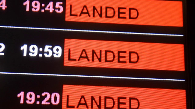 航班降落在机场航站楼的信息板上，选择性聚焦。视频下载