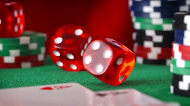 红色骰子按顺序滚动，赌场筹码，绿色毛毡上的卡片视频素材