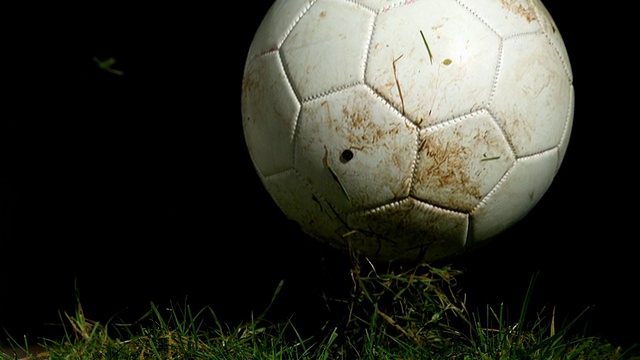 肮脏的足球在草地上弹跳视频素材