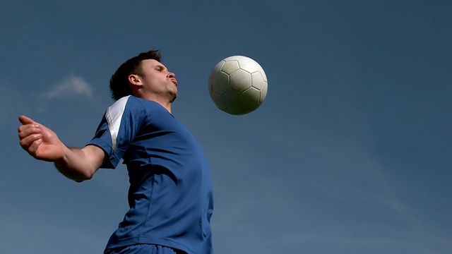 足球运动员在蓝天下用胸触球视频素材