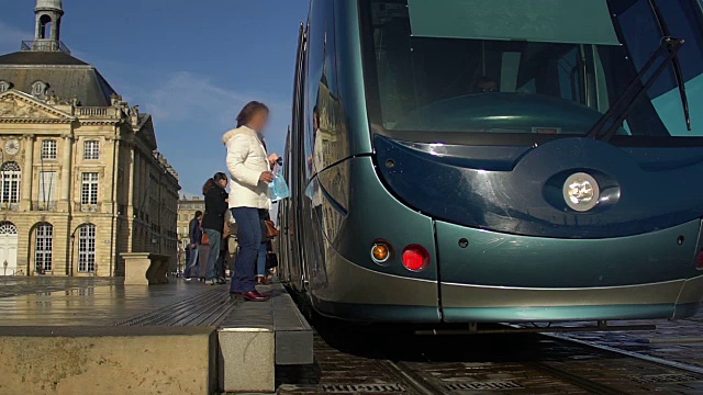 现代蓝色电车驶往电车站，人们进入交通工具视频素材