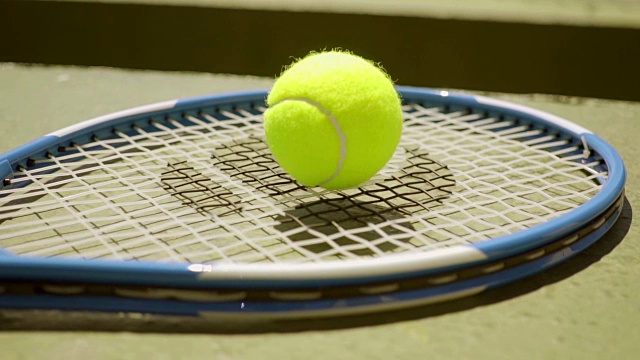 球拍上的彩色霓虹黄色网球视频下载