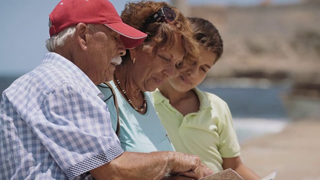 家庭祖父母和男孩在古巴度假看旅游地图视频素材