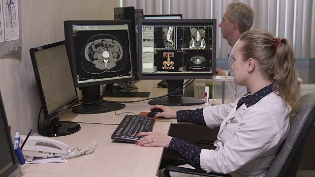 年轻医生在电脑上打字的侧面图视频下载