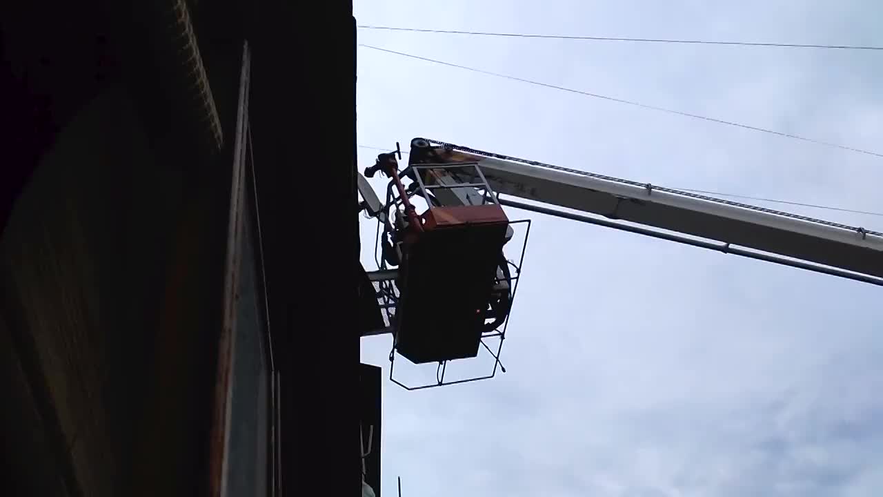 救援电梯上的消防队员通过阳台进入正在燃烧的公寓扑灭大火视频素材