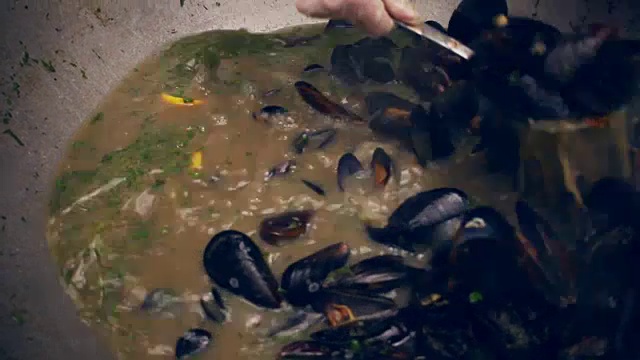 贻贝在锅里。厨师从锅中取出贻贝。美味的海鲜菜肴视频素材
