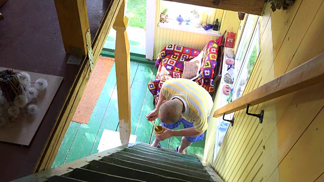村民男子拿着刷漆杆在农村农舍的楼梯上。FullHD视频下载