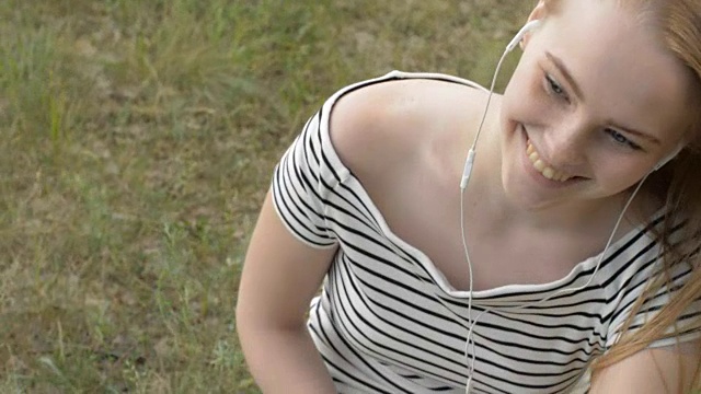 年轻女子戴着耳机在户外视频素材