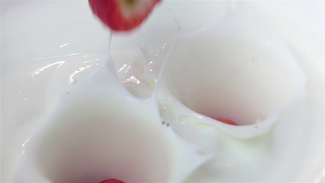 两段草莓落入酸奶的视频，慢镜头视频素材