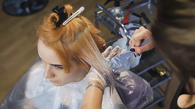 发型师美容工作室将颜料涂在头发上，染成金色视频下载