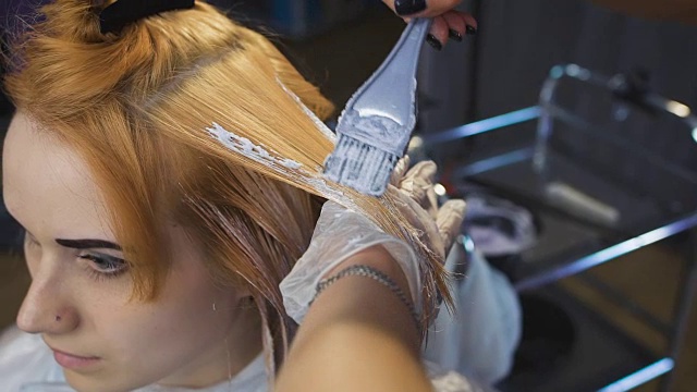 发型师美容工作室将颜料涂在头发上，染成金色视频下载