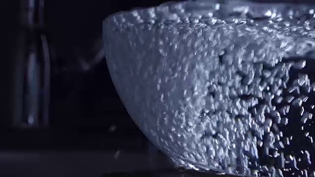 水从水龙头流出一个玻璃碗，慢动作视频视频素材
