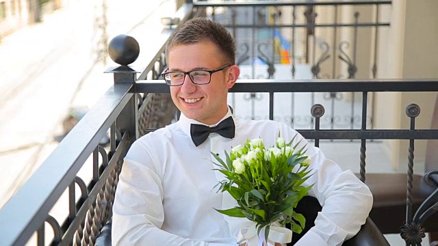 一个年轻人拿着结婚花束坐在阳台上视频下载