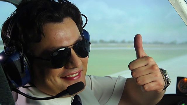 飞行员在驾驶舱内微笑着竖起大拇指，这是职业视频素材