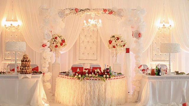 豪华的婚礼大厅在餐厅装饰着红白鲜花视频下载