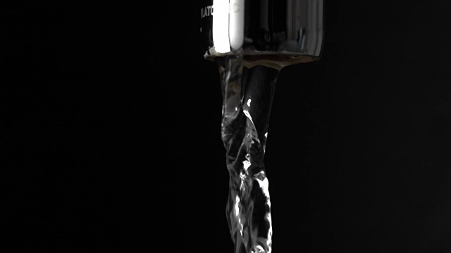 微距慢动作拍摄水从水龙头在黑色背景视频素材