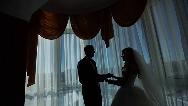幸福奢华的新娘和新郎站在富丽的房间窗前视频下载