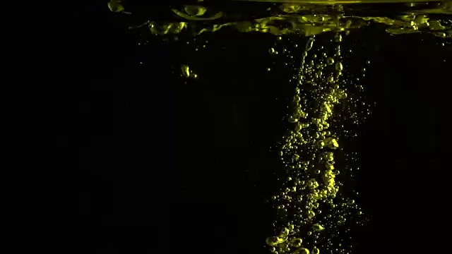 柠檬落入水中，以黑色背景为背景的超慢镜头特写镜头视频下载