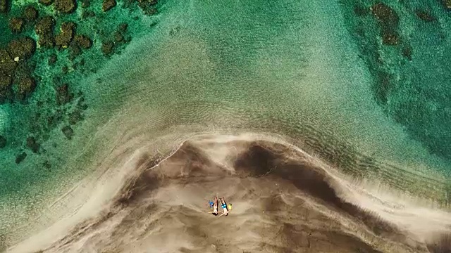 鸟瞰图的年轻夫妇放松在热带海滩度假视频素材