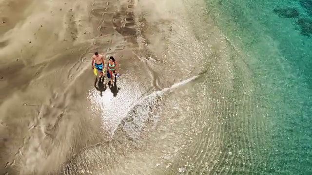 年轻夫妇在热带海滩上度假的鸟瞰图视频素材