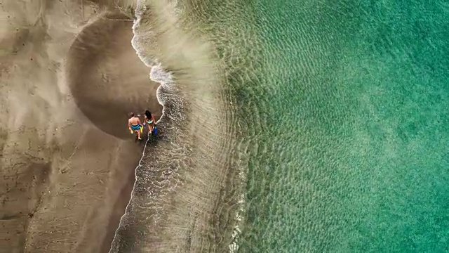 年轻夫妇在热带海滩上度假的鸟瞰图视频素材