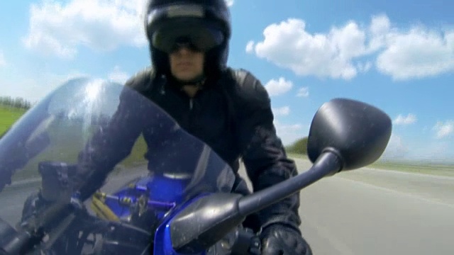 男人坐在摩托车上，在路上行驶视频下载