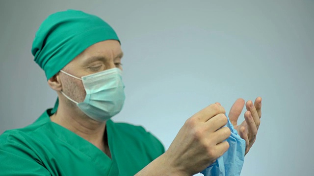 手术失败后失望的外科医生脱下医用手套视频下载