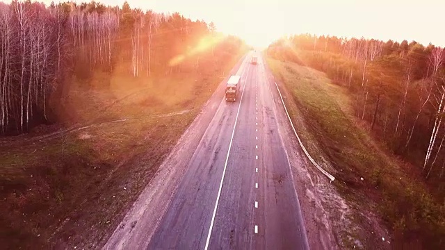 日落时分高速公路上的航班。公路上卡车的鸟瞰图视频下载