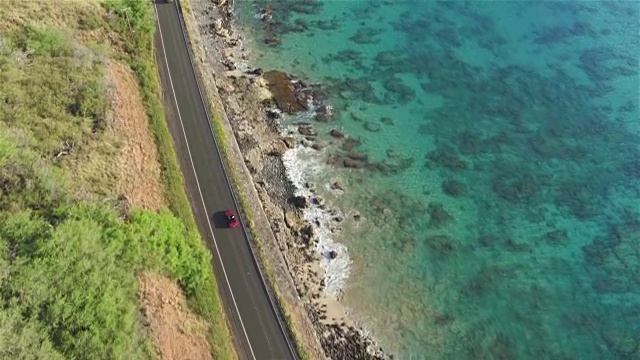 AERIAL:红色敞篷车在火山岛上美丽的海岸公路上行驶视频素材