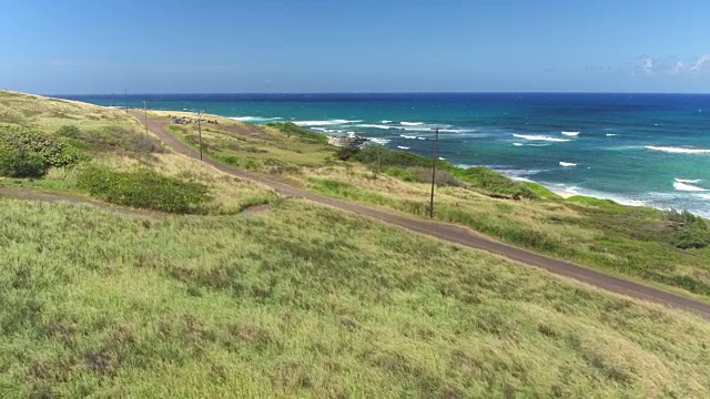 航拍:红色敞篷车沿着茂盛的夏威夷岛的海岸公路行驶视频素材