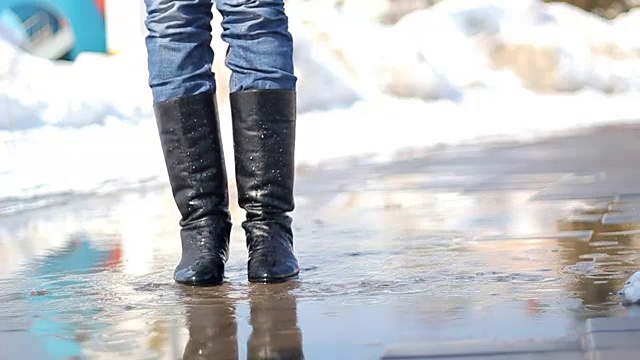 穿着雨靴在水坑里跳的年轻女人视频下载
