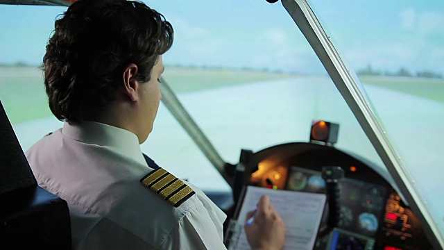忙碌的机组指挥官在飞机驾驶舱专心填写飞行文件视频素材