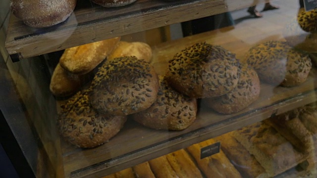 一个女人用手机在面包店里拍面包视频下载