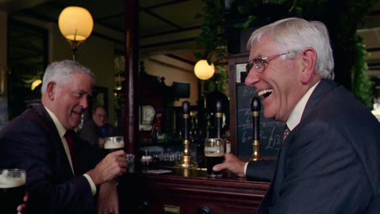三个商人在爱尔兰都柏林的酒吧喝着黑啤酒，谈笑风生视频素材