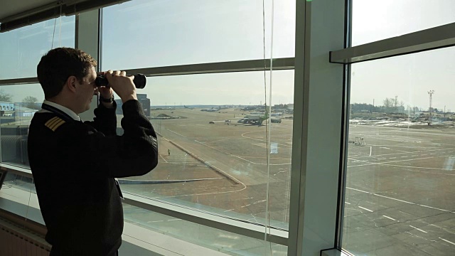 在机场，空中交通管制员正在用双筒望远镜观察距离视频素材