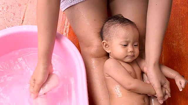 可爱的亚洲小婴儿和妈妈在户外洗澡视频下载