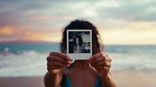 日落时分海滩上美丽年轻女子的宝丽来肖像视频下载