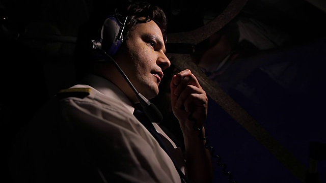 飞行员操纵商用飞机并通过无线电传送信息视频素材